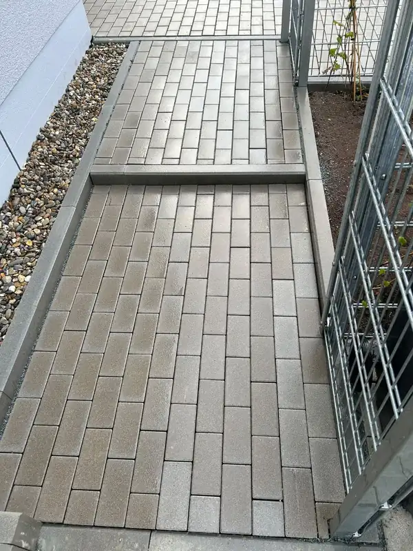 Neu verlegter Pflasterweg mit Stufe und Kiesstreifen